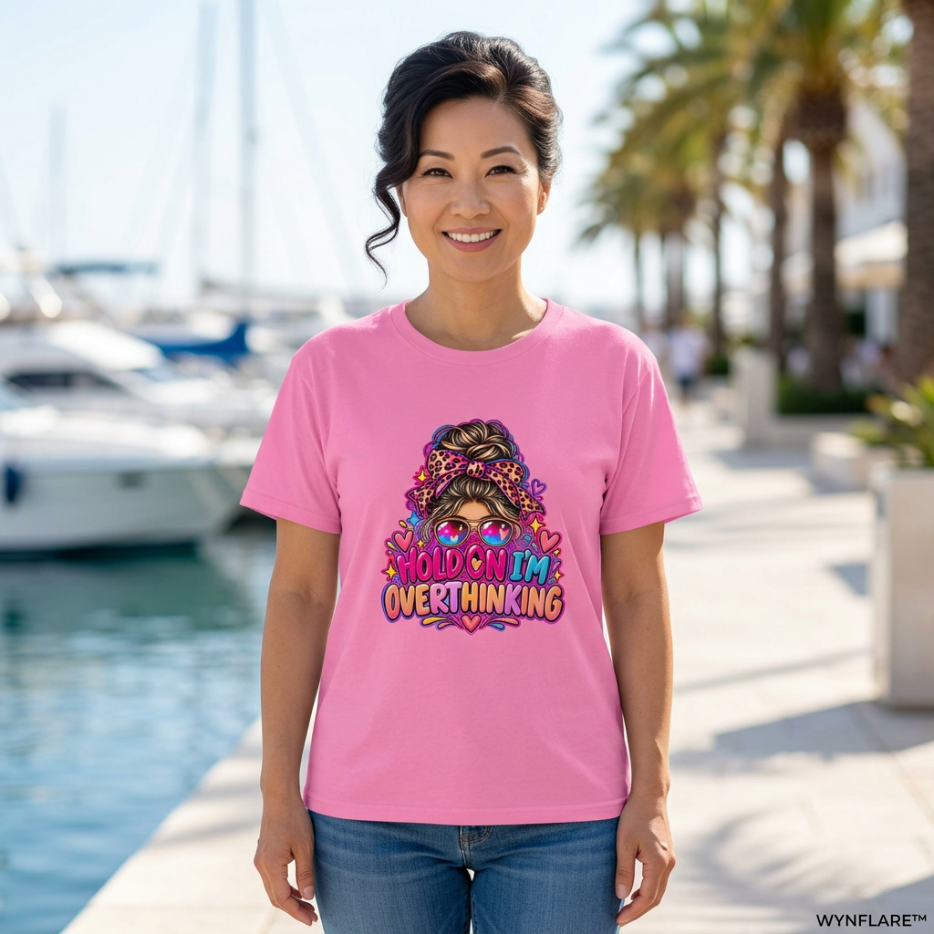Woman wearing the azalea pink Hold On I'm Overthinking graphic tee on a sunny waterfront promenade
